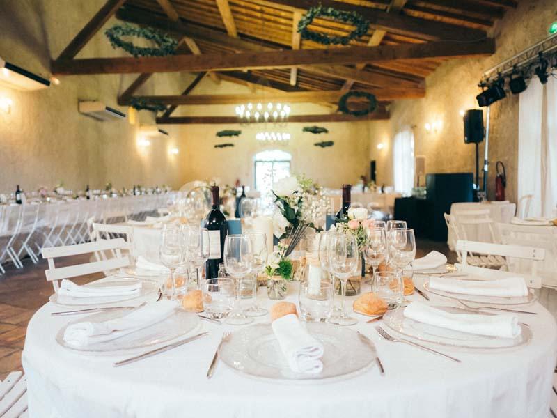 Location salle Pomérols (Hérault) - Domaine Fon de Rey #6 Salle de réception lumineuse avec tables décorées de nappes blanches, vaisselle élégante et fleurs.
