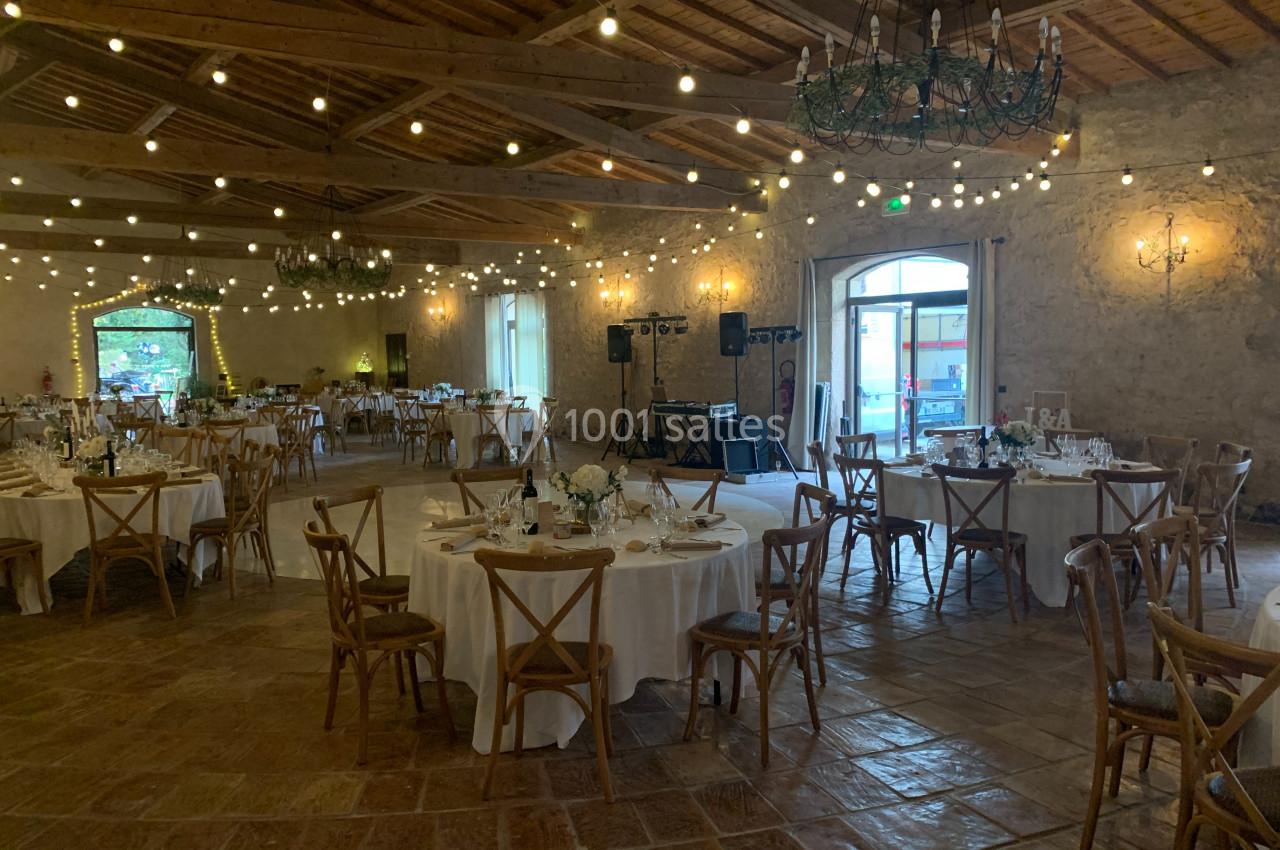 Location salle Pomérols (Hérault) - Domaine Fon de Rey #25 Salle de réception décorée avec des guirlandes lumineuses, tables rondes dressées et chaises en bois.