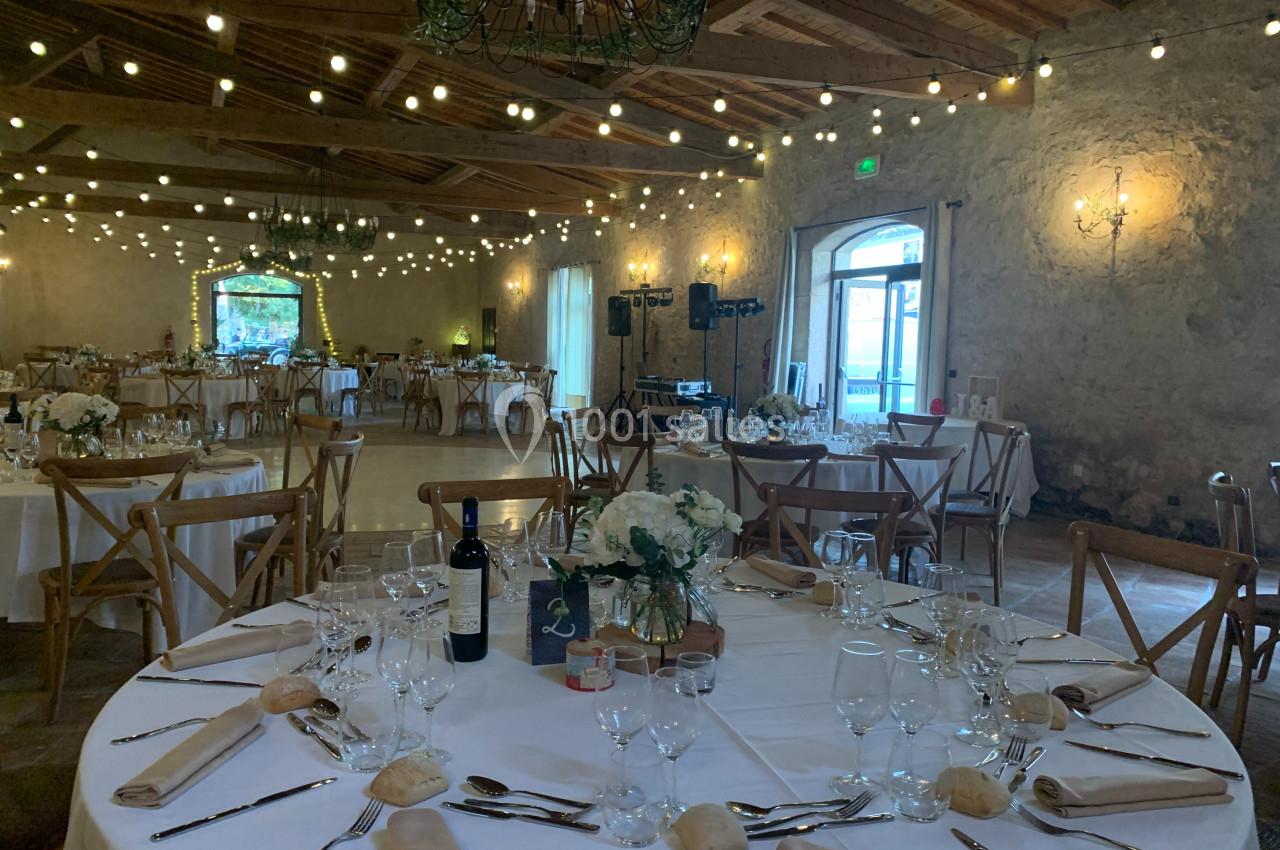 Location salle Pomérols (Hérault) - Domaine Fon de Rey #26 Salle de réception décorée avec des guirlandes lumineuses, tables dressées avec nappes blanches, fleurs et couverts.