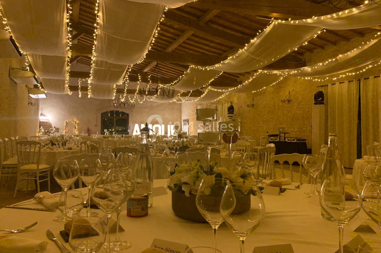 Location salle Pomérols (Hérault) - Domaine Fon de Rey #29 Salle de réception décorée avec des guirlandes lumineuses, tables dressées avec vaisselle et centre de table floral.