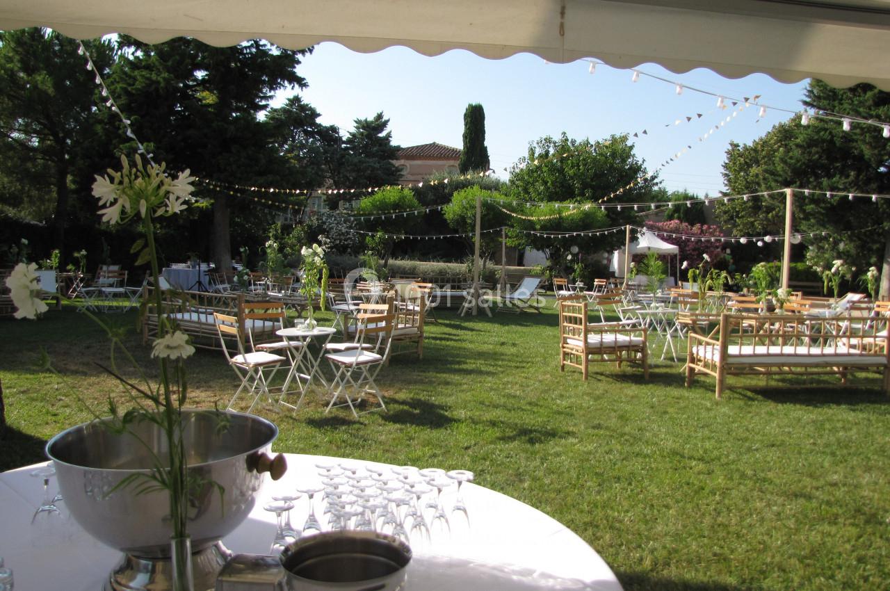 Location salle Pomérols (Hérault) - Domaine Fon de Rey #43 Espace extérieur aménagé pour un événement avec tables, chaises, guirlandes lumineuses et verdure environnante.