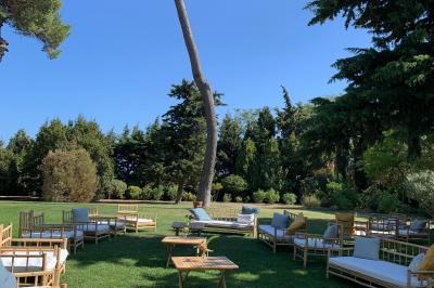 Miniature Location salle Pomérols (Hérault) - Domaine Fon de Rey #44 Piscine extérieure entourée de chaises longues, de végétation luxuriante et de grands arbres sous un ciel bleu.