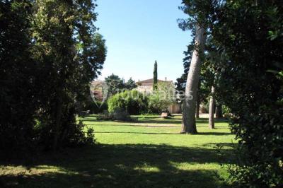 Miniature Location salle Pomérols (Hérault) - Domaine Fon de Rey #21 Piscine extérieure entourée de chaises longues, de végétation luxuriante et de grands arbres sous un ciel bleu.