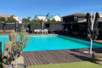Miniature Location salle Cabriès (Bouches-du-Rhône) - Lodge Le Gaya #2 Intérieur d'un bar élégant avec comptoir en marbre sombre, étagères de bouteilles et fauteuils confortables.