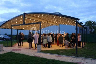 Un groupe de serveurs et serveuses en uniforme posant dans une salle de réception élégante.