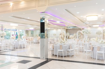 Un groupe de serveurs et serveuses en uniforme posant dans une salle de réception élégante.