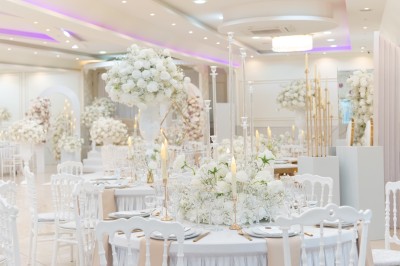 Un groupe de serveurs et serveuses en uniforme posant dans une salle de réception élégante.
