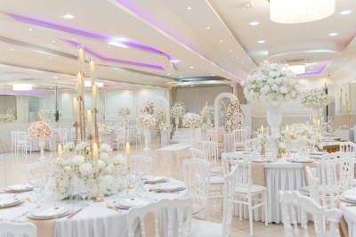 Un groupe de serveurs et serveuses en uniforme posant dans une salle de réception élégante.