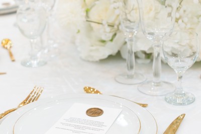 Un groupe de serveurs et serveuses en uniforme posant dans une salle de réception élégante.