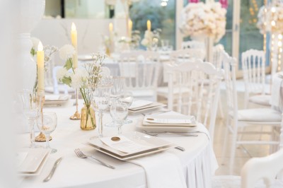 Un groupe de serveurs et serveuses en uniforme posant dans une salle de réception élégante.
