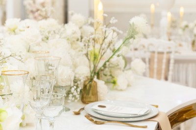 Un groupe de serveurs et serveuses en uniforme posant dans une salle de réception élégante.
