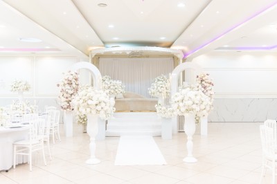 Un groupe de serveurs et serveuses en uniforme posant dans une salle de réception élégante.