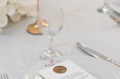 Un groupe de serveurs et serveuses en uniforme posant dans une salle de réception élégante.