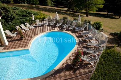 Chambre lumineuse avec parquet en bois, lit double, canapé rouge, table basse et grandes fenêtres avec rideaux fleuris.