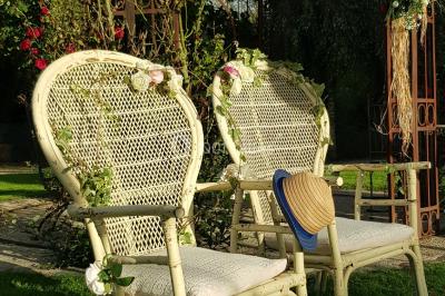 Pressoir ancien en bois dans une pièce avec murs en pierre, plafond à poutres apparentes et sol en parquet.