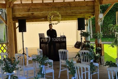 Pressoir ancien en bois dans une pièce avec murs en pierre, plafond à poutres apparentes et sol en parquet.