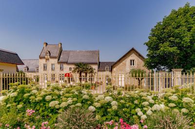 Pressoir ancien en bois dans une pièce avec murs en pierre, plafond à poutres apparentes et sol en parquet.