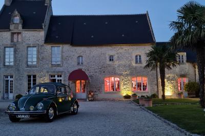 Pressoir ancien en bois dans une pièce avec murs en pierre, plafond à poutres apparentes et sol en parquet.