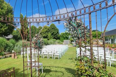 Pressoir ancien en bois dans une pièce avec murs en pierre, plafond à poutres apparentes et sol en parquet.