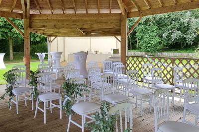 Pressoir ancien en bois dans une pièce avec murs en pierre, plafond à poutres apparentes et sol en parquet.