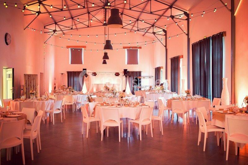 Location salle La Chapelle-Gauthier (Seine-et-Marne) - Nomade-Lodge #3 Salle de réception décorée avec des guirlandes lumineuses, tables rondes dressées et chaises blanches.