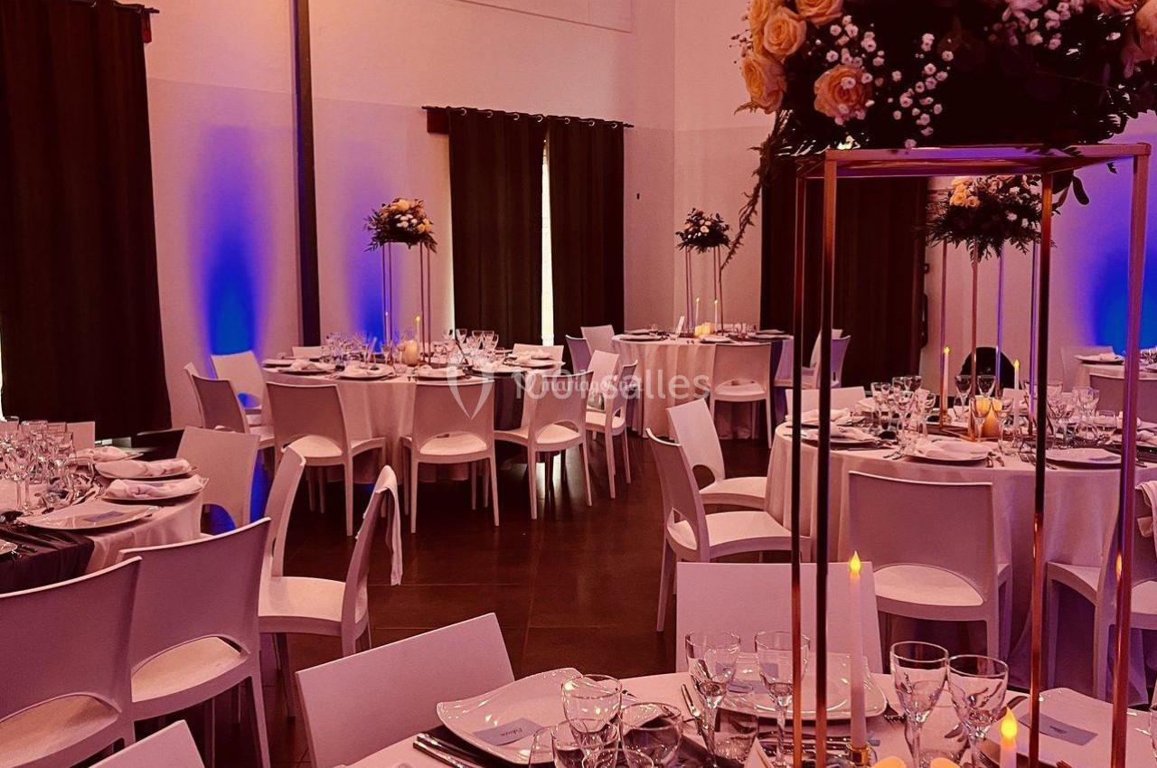 Location salle La Chapelle-Gauthier (Seine-et-Marne) - Nomade-Lodge #34 Salle de réception décorée avec des tables élégantes, des chandelles, des fleurs et un éclairage chaleureux.