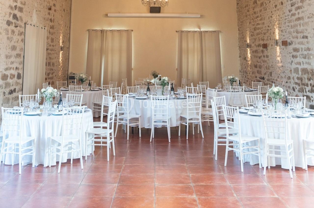 Location salle La Chapelle-Gauthier (Seine-et-Marne) - Nomade-Lodge #45 Salle de réception lumineuse avec des tables rondes dressées, nappes blanches et chaises assorties, décorée de fleurs.