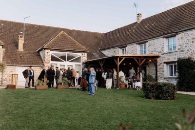 Miniature Location salle La Chapelle-Gauthier (Seine-et-Marne) - Nomade-Lodge #65 Une mariée en robe blanche applaudit devant un groupe de personnes dans un jardin lors d'une célébration.