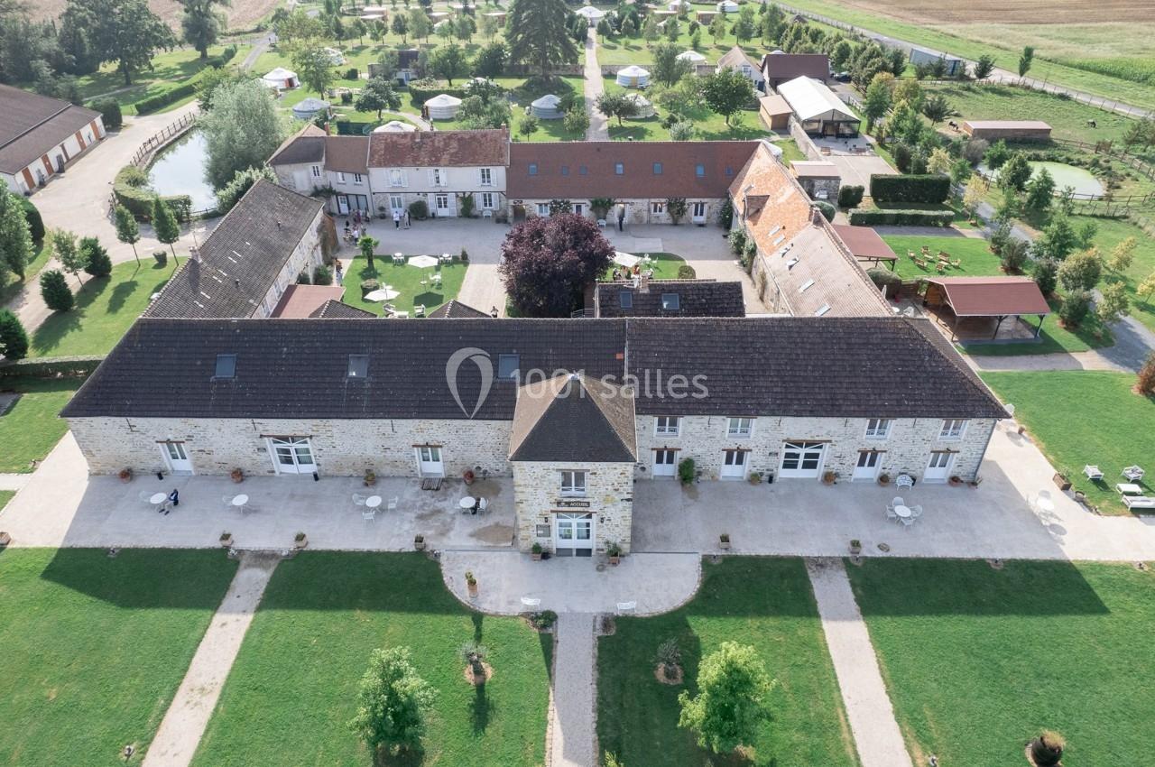 Location salle La Chapelle-Gauthier (Seine-et-Marne) - Nomade-Lodge #68 Vue aérienne d'un domaine avec bâtiments en pierre, jardin aménagé, allées et espaces verts environnants.