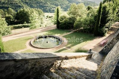 Miniature Location salle Beaujeu (Rhône) - Le Domaine de Vavril #25 Salle voûtée en pierre avec un sol en béton poli, éclairée par des lumières chaudes, et un vase de fleurs au centre.