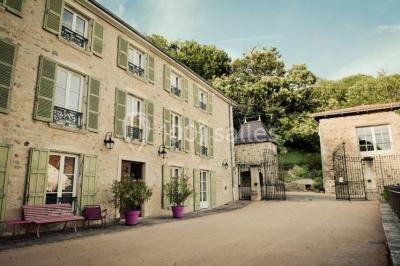 Miniature Location salle Beaujeu (Rhône) - Le Domaine de Vavril #23 Salle voûtée en pierre avec un sol en béton poli, éclairée par des lumières chaudes, et un vase de fleurs au centre.