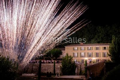 Miniature Location salle Beaujeu (Rhône) - Le Domaine de Vavril #24 Salle voûtée en pierre avec un sol en béton poli, éclairée par des lumières chaudes, et un vase de fleurs au centre.