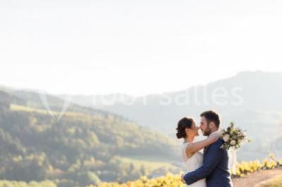 Miniature Location salle Beaujeu (Rhône) - Le Domaine de Vavril #22 Salle voûtée en pierre avec un sol en béton poli, éclairée par des lumières chaudes, et un vase de fleurs au centre.
