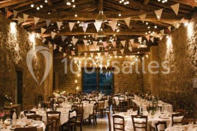 Miniature Location salle Beaujeu (Rhône) - Le Domaine de Vavril #9 Salle voûtée en pierre avec un sol en béton poli, éclairée par des lumières chaudes, et un vase de fleurs au centre.