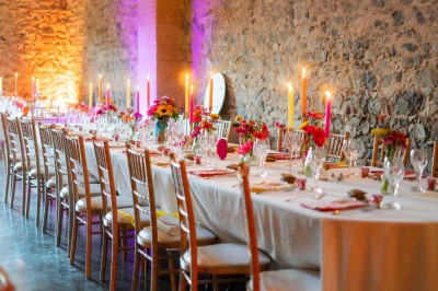 Miniature Location salle Beaujeu (Rhône) - Le Domaine de Vavril #7 Salle voûtée en pierre avec un sol en béton poli, éclairée par des lumières chaudes, et un vase de fleurs au centre.