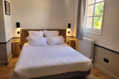 Miniature Location salle Beaujeu (Rhône) - Le Domaine de Vavril #21 Salle voûtée en pierre avec un sol en béton poli, éclairée par des lumières chaudes, et un vase de fleurs au centre.