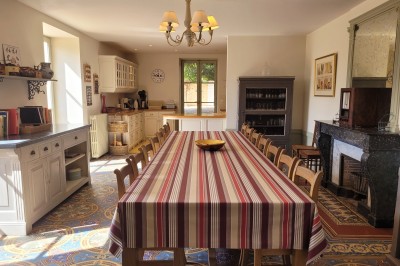 Miniature Location salle Beaujeu (Rhône) - Le Domaine de Vavril #20 Salle voûtée en pierre avec un sol en béton poli, éclairée par des lumières chaudes, et un vase de fleurs au centre.