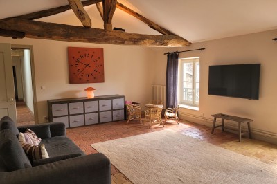 Miniature Location salle Beaujeu (Rhône) - Le Domaine de Vavril #19 Salle voûtée en pierre avec un sol en béton poli, éclairée par des lumières chaudes, et un vase de fleurs au centre.