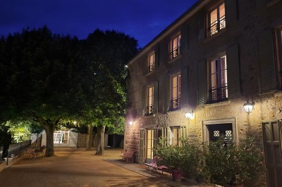 Miniature Location salle Beaujeu (Rhône) - Le Domaine de Vavril #33 Salle voûtée en pierre avec un sol en béton poli, éclairée par des lumières chaudes, et un vase de fleurs au centre.