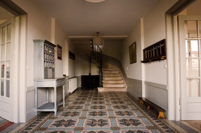 Miniature Location salle Beaujeu (Rhône) - Le Domaine de Vavril #13 Salle voûtée en pierre avec un sol en béton poli, éclairée par des lumières chaudes, et un vase de fleurs au centre.