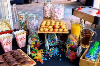 Salle de conférence lumineuse avec rangées de chaises alignées, écran de projection et portes vitrées au fond.