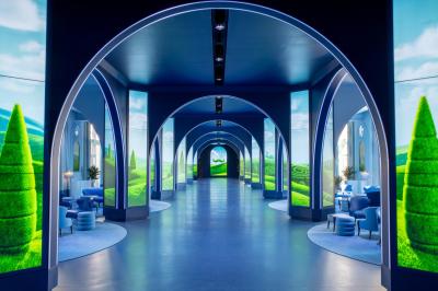 Salle de conférence lumineuse avec rangées de chaises alignées, écran de projection et portes vitrées au fond.