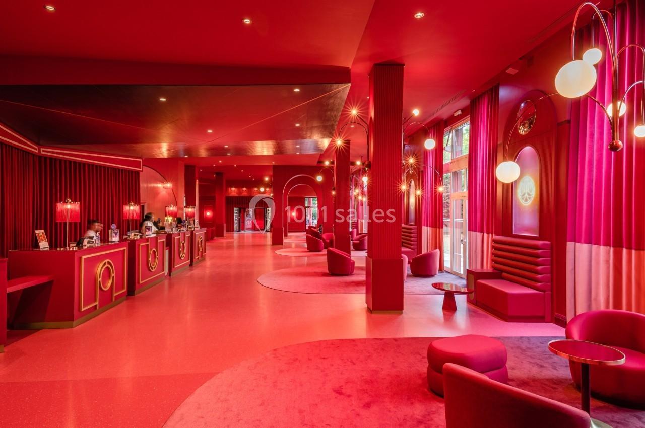 Intérieur d'un espace moderne aux tons rouges avec mobilier design, comptoirs et éclairage décoratif.