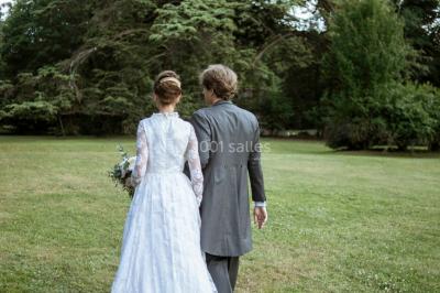 Façade d'un château éclairé au crépuscule, vue depuis un parterre de fleurs au premier plan.