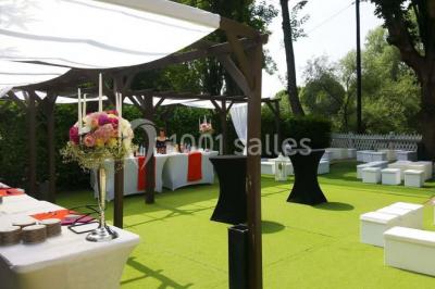 Chemin ombragé bordé d'arbres longeant une rivière calme, avec une barrière en bois sur le côté.