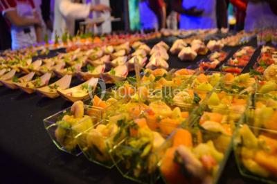 Chemin ombragé bordé d'arbres longeant une rivière calme, avec une barrière en bois sur le côté.