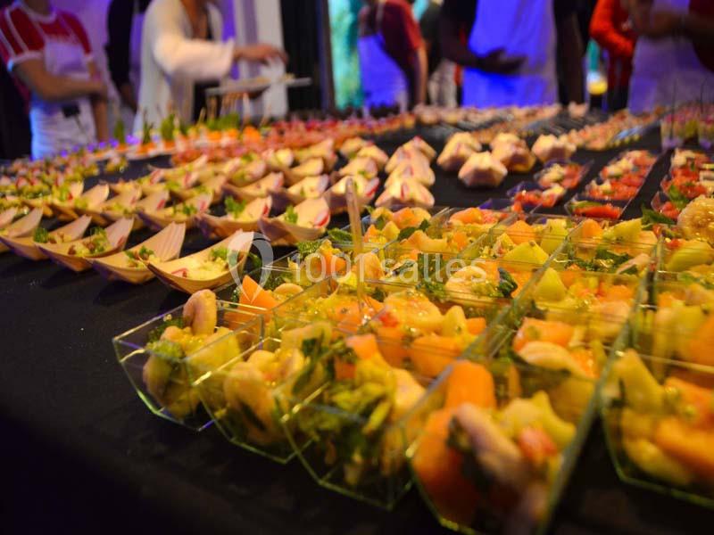 Buffet coloré composé de verrines et amuse-bouches variés disposés sur une table noire.