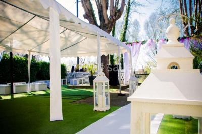 Chemin ombragé bordé d'arbres longeant une rivière calme, avec une barrière en bois sur le côté.