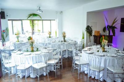 Chemin ombragé bordé d'arbres longeant une rivière calme, avec une barrière en bois sur le côté.