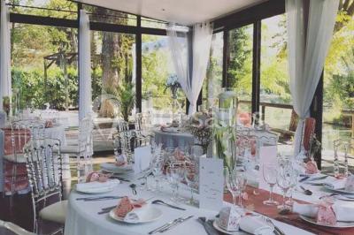 Chemin ombragé bordé d'arbres longeant une rivière calme, avec une barrière en bois sur le côté.